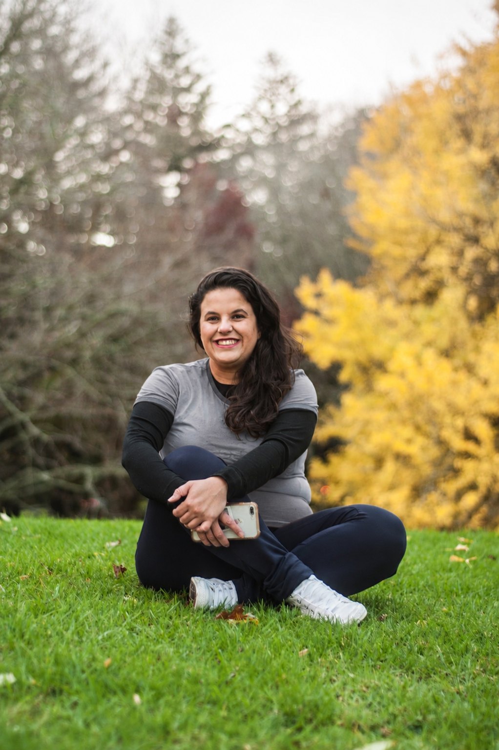 Isis Oliveira sitting outdoors